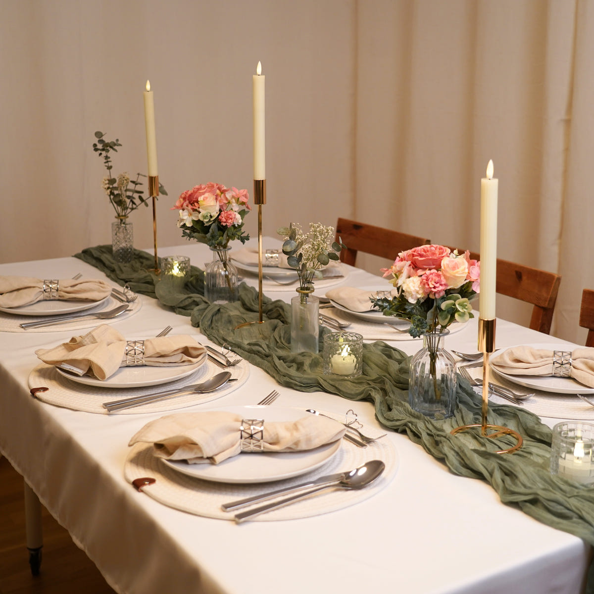 Tisch in Salbeigrün und Silber mit Musselinläufer, Teelichtern und Gedecken mit Silberbesteck